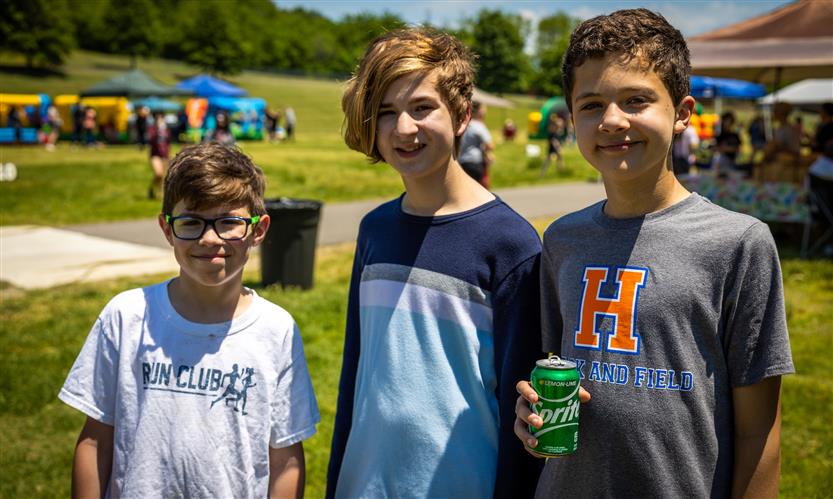 Three boys smile while outside